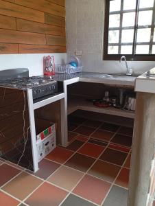 a kitchen with a stove and a sink at Cabañas La Cima Del Cielo in San Vicente de Chucurí