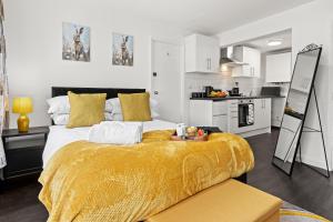 a bedroom with a large bed with a yellow blanket at Cheshire Gold- studio apartment, Warrington in Warrington
