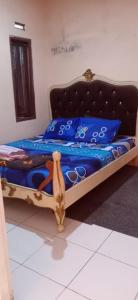 a bed in a room with a blue comforter at Mutiara Dieng in Wonosobo