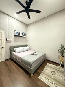 a bedroom with a bed and a ceiling fan at BELLA COTTAGE in Pantai Cenang