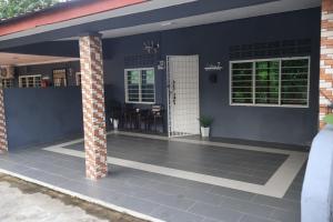 a house with a blue wall and a brick pillar at BELLA COTTAGE in Pantai Cenang
