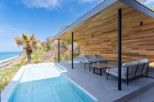 an outdoor patio with a table and chairs and the ocean at KONA OCEAN Club in Awaji