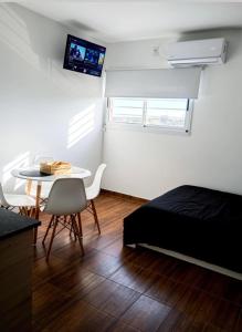 a bedroom with a bed and a table and a tv at Apart Casa de Piedra in San Luis