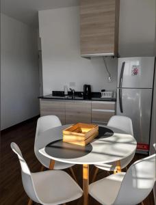 a kitchen with a table and chairs and a refrigerator at Apart Casa de Piedra in San Luis