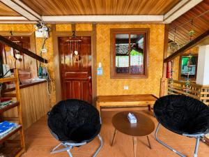 a living room with two chairs and a table at Nay Carmen Pension House Port Barton in Itaytay