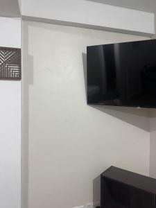 ein Flachbildfernseher, der an einer Wand hängt in der Unterkunft Studio Flat in Dominika
