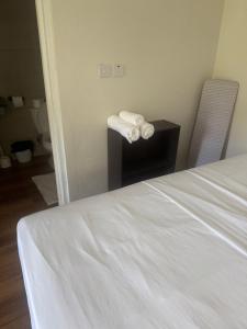 ein Zimmer mit einem Bett und einem Tisch mit Handtüchern in der Unterkunft Studio Flat in Dominika