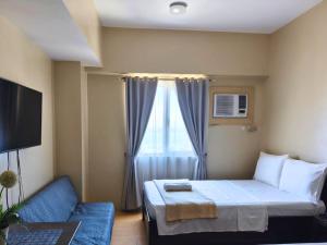 a hotel room with a bed and a window at Sunvida Tower Stays Across SM City Cebu in Cebu City