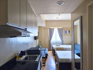 a small room with two beds and a kitchen at Sunvida Tower Stays Across SM City Cebu in Cebu City