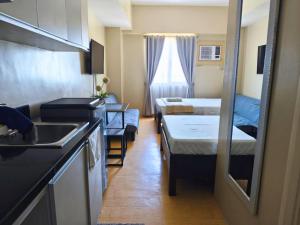 a small room with two beds and a kitchen at Sunvida Tower Stays Across SM City Cebu in Cebu City