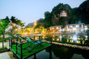 a resort with a lake and a mountain at night at Hang Mua Eco Park in Ninh Binh