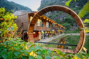 a building with a pond in front of it at Hang Mua Eco Park in Ninh Binh