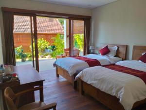 a hotel room with two beds and a window at Le Jardin in Amed