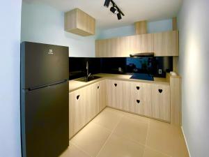 a kitchen with a black refrigerator and a sink at The View Boutique Hotel in Vung Tau