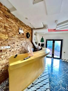 a man sitting at a bar in a room with a brick wall at FOCUS hotel in Baham