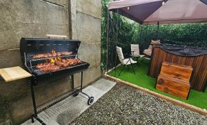 a grill with meat on it next to a patio at Cabañas JP puerto montt in Puerto Montt