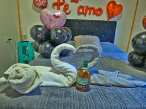 a bed with towels and balloons and a bottle of alcohol at Cabañas JP puerto montt in Puerto Montt
