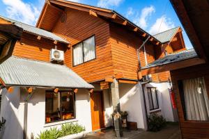 a wooden house with a roof at Hotel El Coihue in Pucón