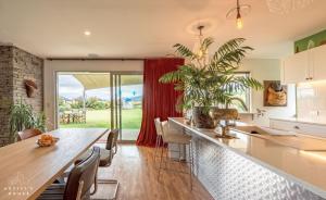 a kitchen and dining room with a table and a plant at The Artist's House Wanaka in Luggate