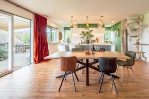 a kitchen and dining room with a wooden table and chairs at The Artist's House Wanaka in Luggate +24 photos
