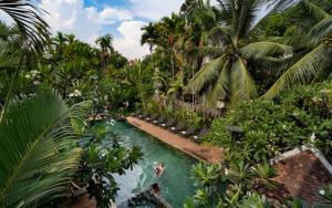 a pool in a resort with palm trees and people in it at Home Indochine d'Angkor Hotel in Siem Reap +130 photos