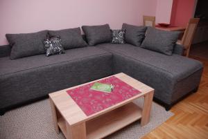 a living room with a gray couch with a coffee table at Apartman Milkovic 2 in Sombor