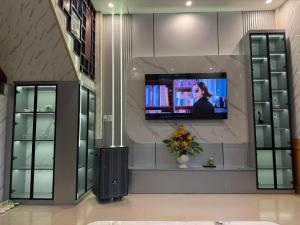 a room with a tv on a wall at SU HOUSE Huế in Hương Trà +5 photos