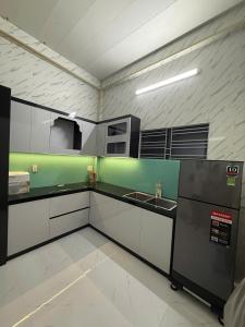 an empty kitchen with a sink and a refrigerator at SU HOUSE Huế in Hương Trà