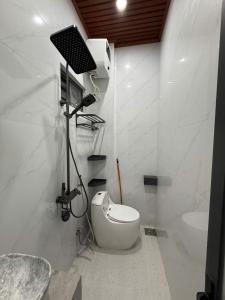 a white bathroom with a toilet and a sink at SU HOUSE Huế in Hương Trà
