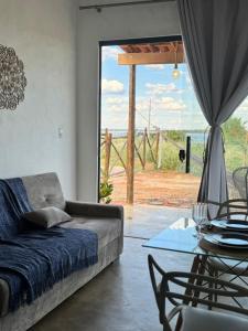 a living room with a couch and a glass table at Chalé Mansões do Rio in Casa Nova