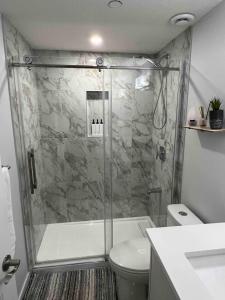 a bathroom with a shower and a toilet at Charming 1Bd Basement Suite with Private Entrance in Calgary +12 photos