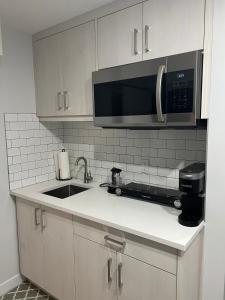 a kitchen with a sink and a microwave at Charming 1Bd Basement Suite with Private Entrance in Calgary
