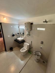 a bathroom with a toilet and a sink at Hotel Devidyar in Manāli