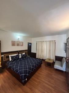 a bedroom with a bed and a couch and a chair at Hotel Devidyar in Manāli