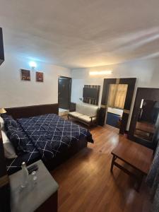 a bedroom with a bed and a couch in it at Hotel Devidyar in Manāli