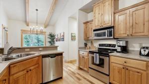 a kitchen with wooden cabinets and stainless steel appliances at Sunset Cabin in McCall