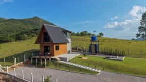 a small house on a hill next to a field at Chalé em laguna in Pescaria Brava