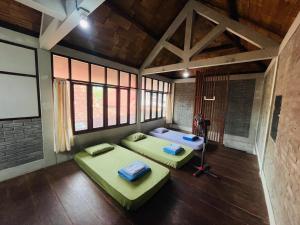 a room with two beds in it with windows at Saka Homestay Boutique & Cafe in Borobudur