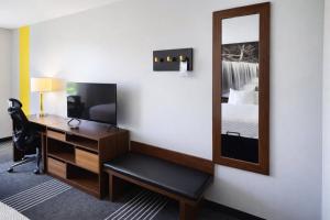 a hotel room with a desk and a mirror at Super 8 by Wyndham Salina I-70 in Salina