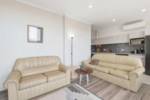 a living room with two couches and a table at MONA Vista, Tasmania in Rosetta