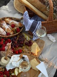 a table with baskets of cheese and bread and glasses of wine at Poets Cottage c1912 Scenic Hikes, Fire, Spa Bath in Wentworth Falls