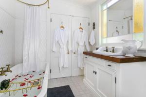 a white bathroom with a bath tub and a sink at Gowan Brae Cottage - NEW! in Katoomba