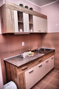 a kitchen with white cabinets and a sink at Apartman Milkovic 2 in Sombor