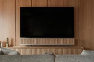 a flat screen tv in a living room with a couch at TOMI Ginza in Tokyo