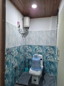 a bathroom with a toilet with blue and white tiles at Aadharjun Homestay in Chidām +19 photos