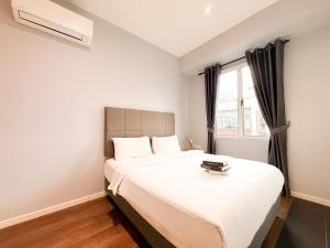a bedroom with a large white bed and a window at Havona Boutique Hotel - Mount Austin - Self Check-in in Johor Bahru