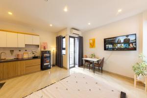 a kitchen and dining room with a table and a tv on the wall at Gấu Studio Ngoại Giao Đoàn in Hanoi