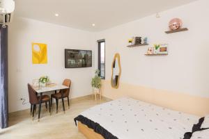 a bedroom with a bed and a table and chairs at Gấu Studio Ngoại Giao Đoàn in Hanoi