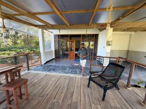 a man standing on the porch of a house at Ella 96TN Resort in Ella
