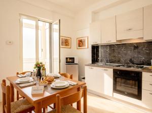 a kitchen with a wooden table with chairs and a dining room at Bari Home in Bari